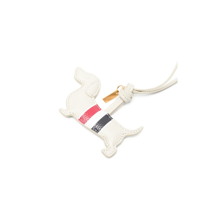 beige dog-shaped keyring with gold-tone hardware by Selfnex